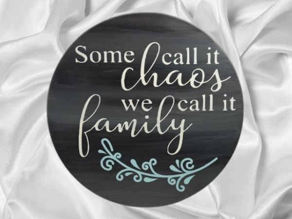 charming and elegant wood round sign that reads some call it chaos we call it family; colors are barnwood stain with ivory and light blue lettering