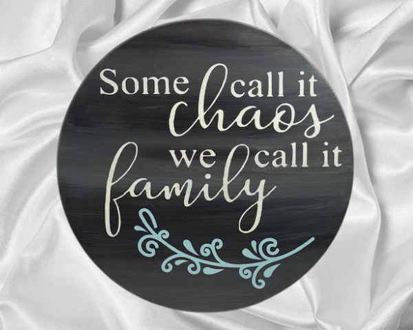 charming and elegant wood round sign that reads some call it chaos we call it family; colors are barnwood stain with ivory and light blue lettering