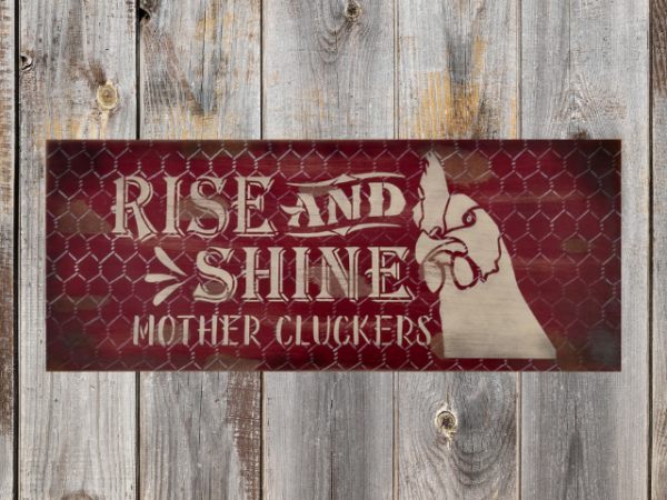 distressed and rustic red background sign with silver chicken wire - signs reads Rise and Shine Mother Cluckers