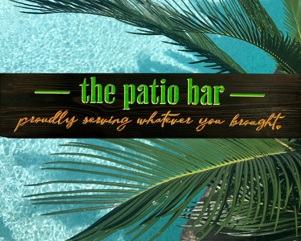 colorful lime green, orange, and yellow sign that reads "the patio bar - proudly serving whatever you brought"