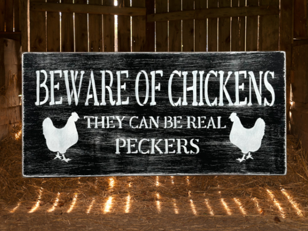 black and white distressed sign that reads "beware of chickens, they can be real peckers"