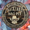 wood round pine rustic BBQ sign that reads Welcome to our Backyard BBQ - we like our meat rubbed and our pork pulled