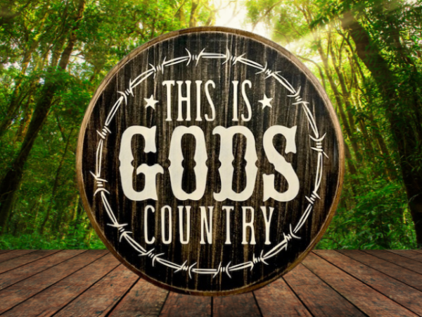 beautiful black and white pine wood round sign that reads "This is Gods Country" with painted barbed wire around the sign