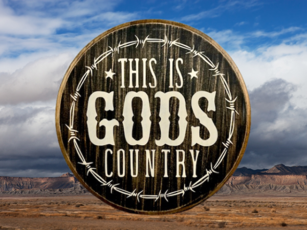 beautiful black and white pine wood round sign that reads "This is Gods Country" with painted barbed wire around the sign