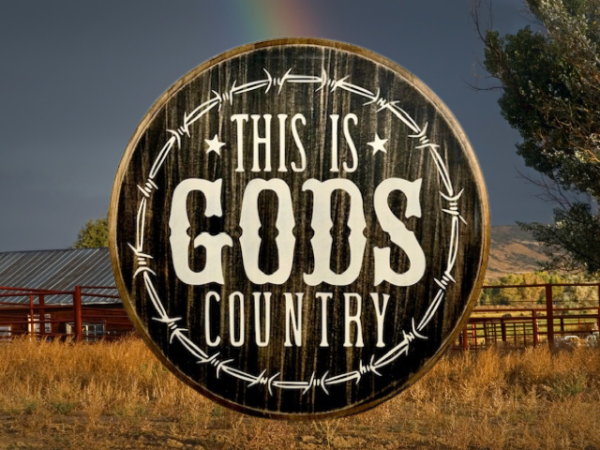 beautiful black and white pine wood round sign that reads "This is Gods Country" with painted barbed wire around the sign