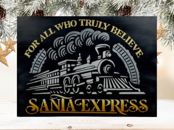 Christmas sign featuring a black background with the words For All Who Truly Believe The Santa Express painted in orange, yellow, and white ombre letters surrounding a white Christmas train