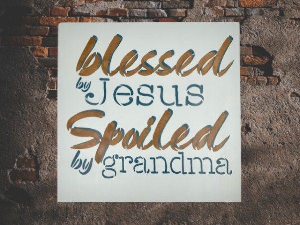 sign that reads "Blessed by Jesus Spoiled by Grandma" on a calm, pastel blue background