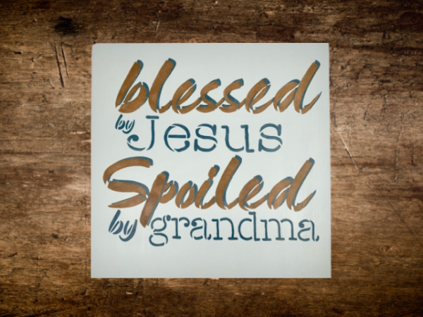 sign that reads "Blessed by Jesus Spoiled by Grandma" on a calm, pastel blue background