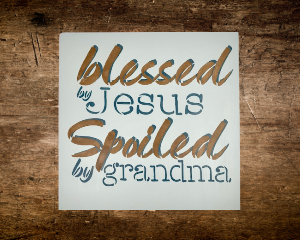 sign that reads "Blessed by Jesus Spoiled by Grandma" on a calm, pastel blue background