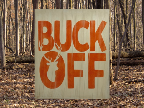 rustic tan hunting sign with orange letters that says "Buck Off