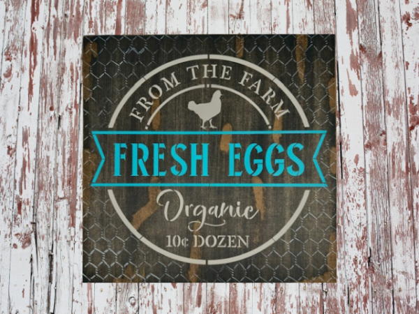 brown rustic and distressed sign with vibrant teal and tan lettering - sign says Fresh Eggs from the Farm