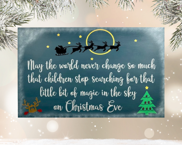 May the world never change Christmas sign is on a night sky background with santa and his reindeer flying over