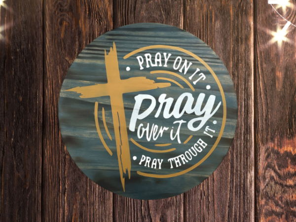 inspirational pine wood round sign with a Phantom Gray stain background - cross is in hazelnut and lettering that reads Pray on it, Pray over it, Pray through it - in Silver lining gray