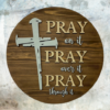 laser-etched inspirational pine wood round sign that reads Pray on it, Pray over it, Pray through it - Early American stain with Buff and Copen blue lettering