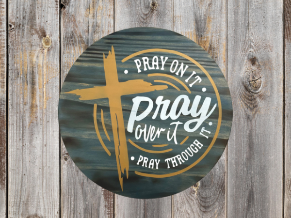 inspirational pine wood round sign with a Phantom Gray stain background - cross is in hazelnut and lettering that reads Pray on it, Pray over it, Pray through it - in Silver lining gray