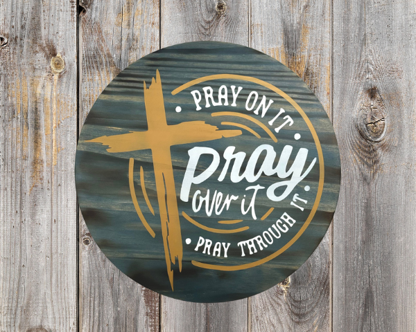 inspirational pine wood round sign with a Phantom Gray stain background - cross is in hazelnut and lettering that reads Pray on it, Pray over it, Pray through it - in Silver lining gray