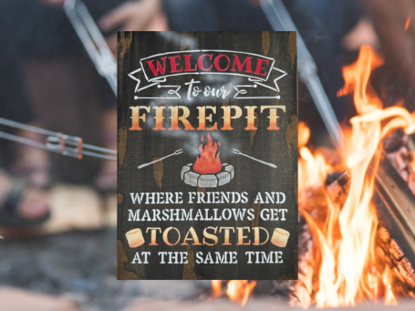 rustic campfire sign that reads "Welcome to our Firepit in beautiful orange and yellow ombre letters - the phrase "where friends and marshmallows get toasted at the same time" are painted at the bottom