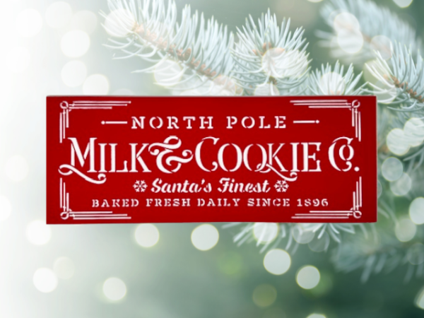 festive holiday sign with a Christmas red background and crisp white lettering that says "North Pole Milk & Cookies Co"