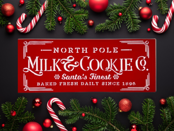 festive holiday sign with a Christmas red background and crisp white lettering that says "North Pole Milk & Cookies Co"