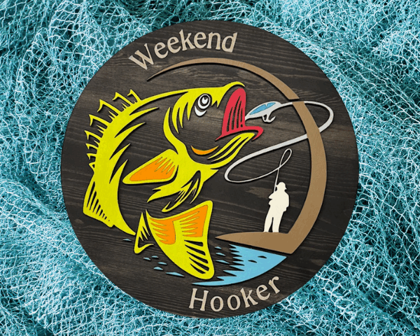 a rustic pine wood sign with a black stain finish, featuring laser-cut "Weekend Hooker" text, a vibrant lime green fish, and a fisherman silhouette, blending bold humor and fishing charm