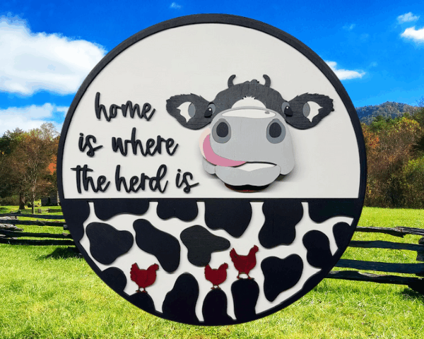 3D laser-cut cow sign with a cow licking his lips, three red chickens running across a cow-print bottom, and the phrase "Home is Where the Herd Is"